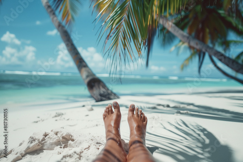 Pieds en eventail sur le sable face à la mer et les palmiers, vacances