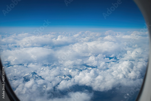 Aerial of snowcapped mountains in eastern Canada under cloudy sky seen through an aiplane window