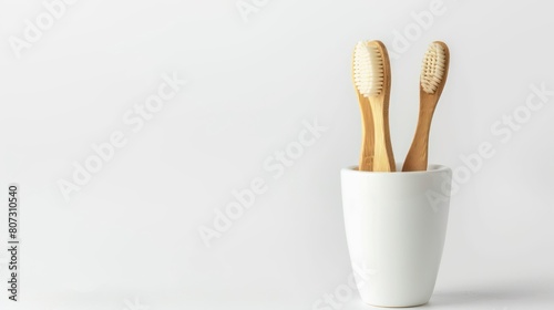 natural eco friendly toothbrush with wooden bamboo handle in a white cup