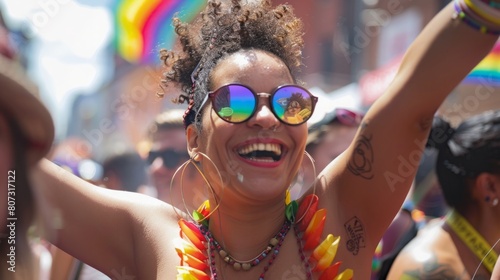 A woman with sunglasses on her head wearing a vibrant rainbow shirt.