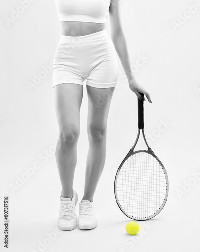 A beautiful attractive girl in white shorts and a top plays tennis. The concept of sports and healthy lifestyle. © Dimid