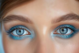 A detailed view of a womans face showing her striking blue eyes up close