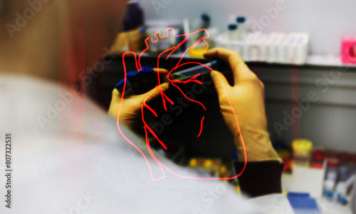 Lab person and drawn heart, Laboratory person checking a sample with outline of biological heart over the top