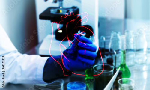 Lab person and drawn heart A, Laboratory person checking a sample with outline of biological heart over the top