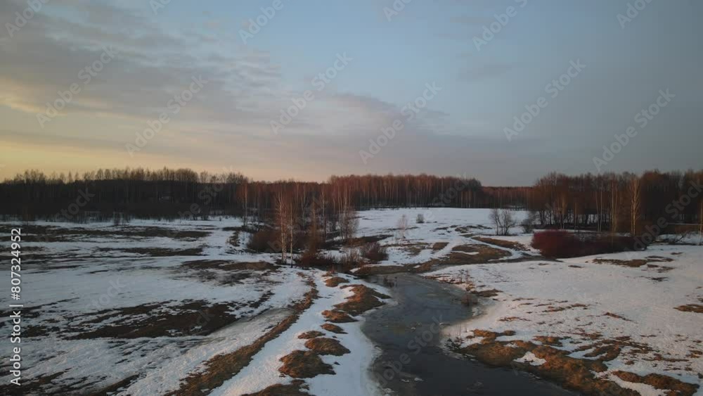 Beautiful spring nature as the snow begins to melt. The first streams and thawed areas, wildlife comes to life after winter against the backdrop of sunset Beautiful spring nature as the snow begins to melt. The first streams and thawed areas, wildlife comes to life after winter against the backdrop of sunset