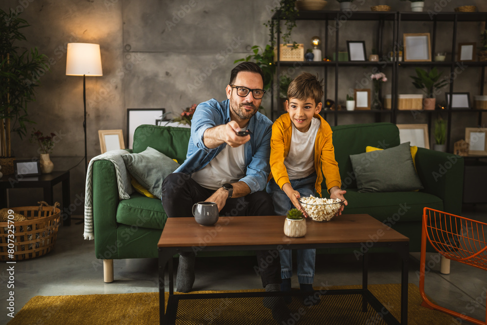 Father and son watch football match and cheer at home Father and son watch football match and cheer at home