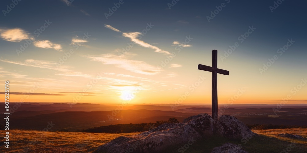 Sunset cross on mountain overlooking valley