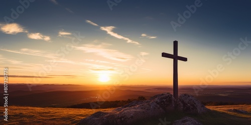 Sunset cross on mountain overlooking valley