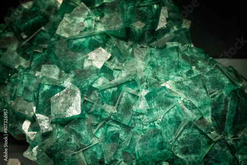 Fluorite stone wallpaper. Textured background of green stone. Crystal gemstone under the lights