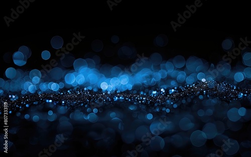 Dark background with dispersed glowing blue bokeh lights. photo