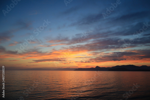 A beautiful sunset with clouds over the sea and the coastline