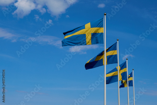 Swedish flags. Four swedish flags on blue sky. Swedish flags fluttering on wind. National Day of Sweden. Swedish Flag Day. 