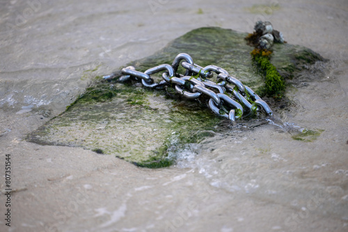 Steel chain on concrete by the sea photo