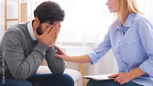 Professional help. Depressed man crying at psychotherapy in despair, psychologist consoling stressed patient