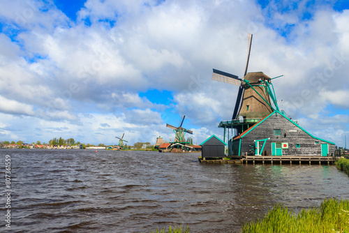 Traditional dutch windmills at the Zaan river in Zaanse Schans village, Netherlands photo