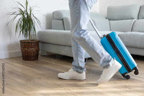 Man leaving home with travel suitcase