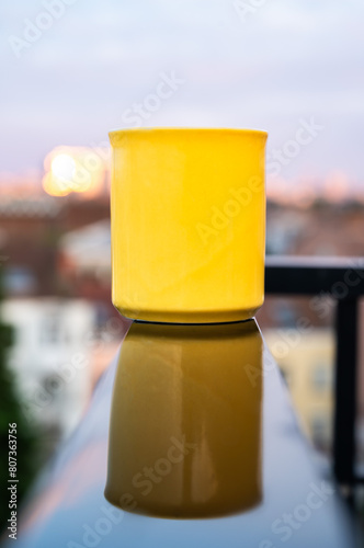 Yellow mug reflecting in a wet black sruface, Belgium photo