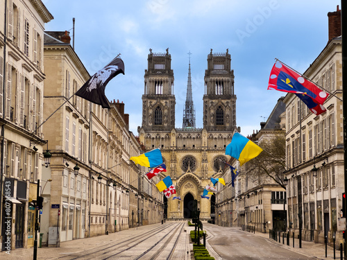 Street Joan of Arc with flags leading to majestic Gothic church photo