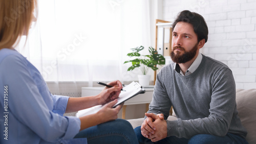 At psychotherapist. Millennial man talking to specialist at therapy session, free space photo
