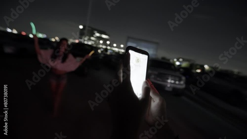 A woman takes a picture of her friend at a country music concert photo