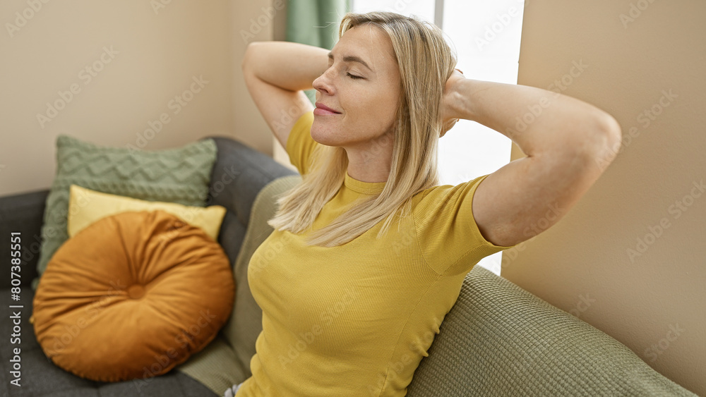 Relaxed blonde woman enjoying comfort in a modern living room interior. Relaxed blonde woman enjoying comfort in a modern living room interior.