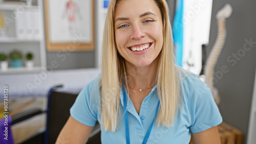 A smiling blonde woman in a blue shirt posing in a modern clinic interior, evoking healthcare professionalism photo