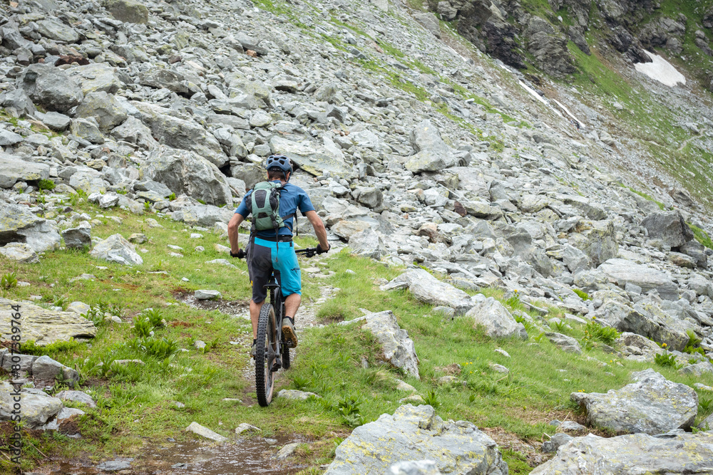 Outdoor extreme sport: Mountain biker riding bike downhill on a rocky mountain