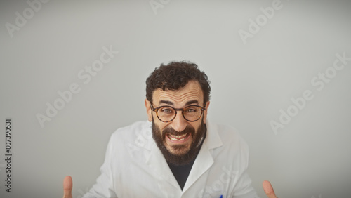 Middle-aged man with beard in lab coat and glasses gestures animatedly against a white background