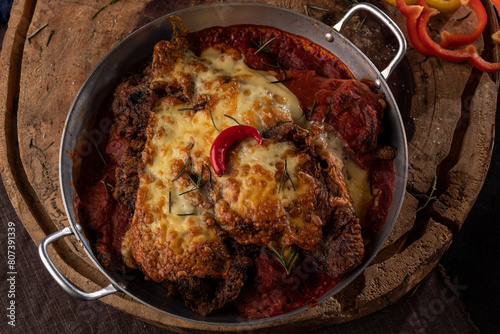 Bife à Parmegiana em panela de alumínio com pimenta decorativa