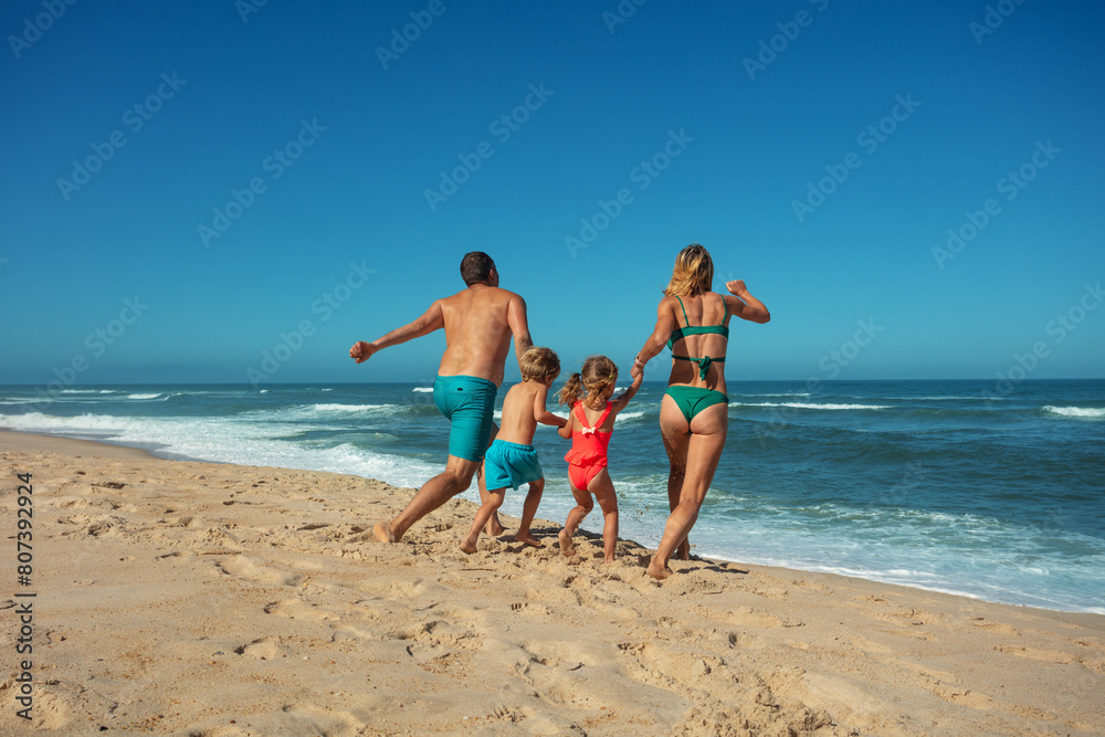 Family enjoys sunny beach day together walk along sandy seashore