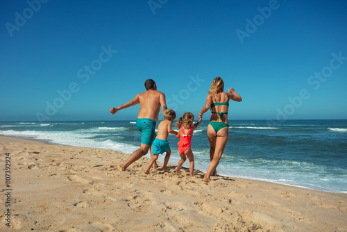 Family enjoys sunny beach day together walk along sandy seashore