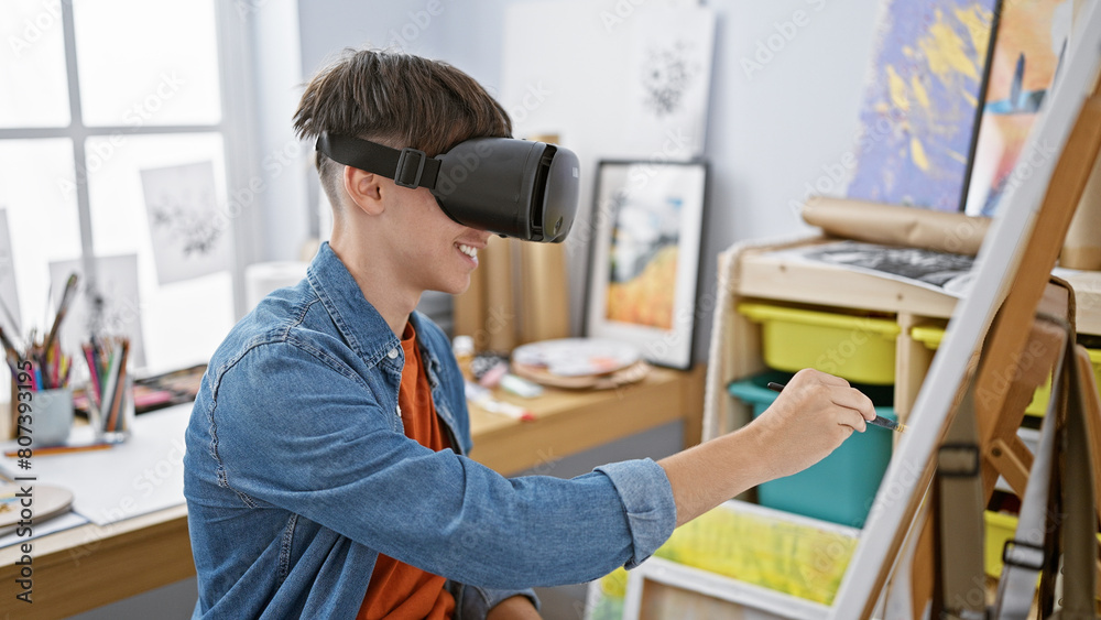 A young man interacting with virtual reality equipment while painting in a bright, modern studio setting. A young man interacting with virtual reality equipment while painting in a bright, modern studio setting.