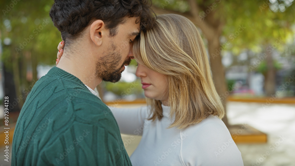 Intimate couple embracing in a tranquil outdoor park, portraying love and a deep connection between a young man and woman. Intimate couple embracing in a tranquil outdoor park, portraying love and a deep connection between a young man and woman.