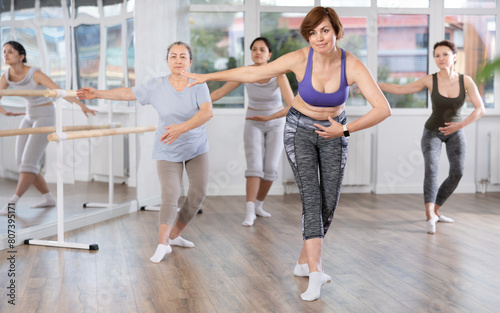 Group of women of different ages are learning various dance and ballet movements in the studio