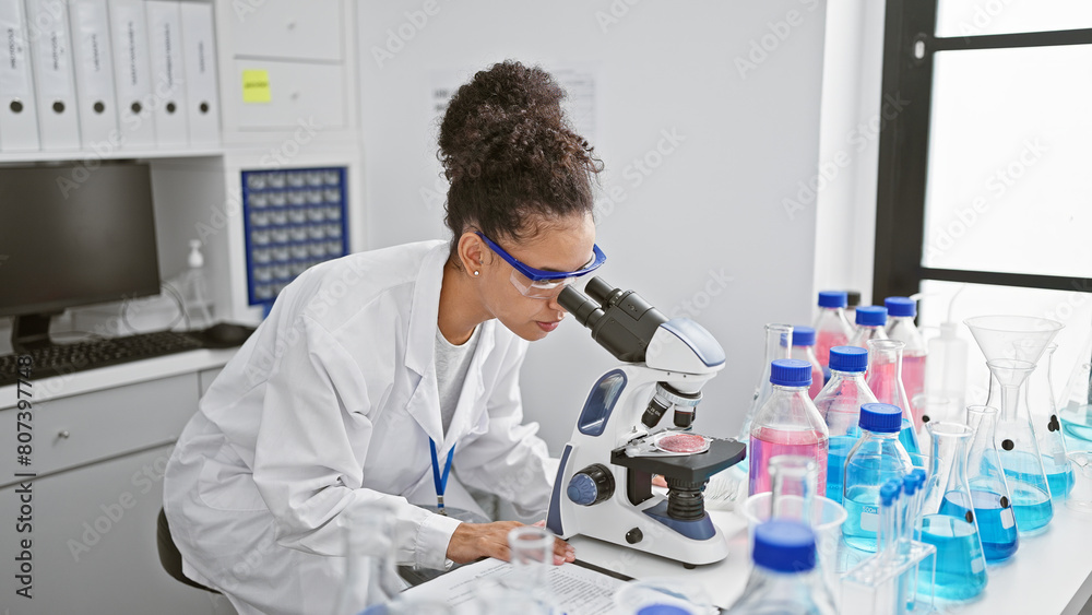 Young beautiful hispanic woman scientist using microscope at laboratory Young beautiful hispanic woman scientist using microscope at laboratory