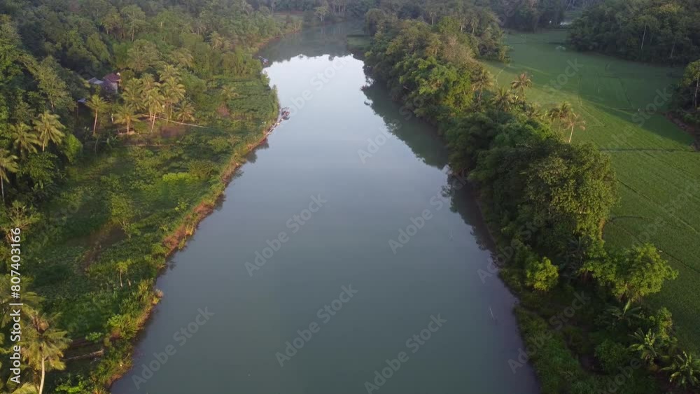 a serene river flowing through a lush green landscape. The river is flanked by dense forests on both sides, with tall trees casting shadows on the calm water. a serene river flowing through a lush green landscape. The river is flanked by dense forests on both sides, with tall trees casting shadows on the calm water.