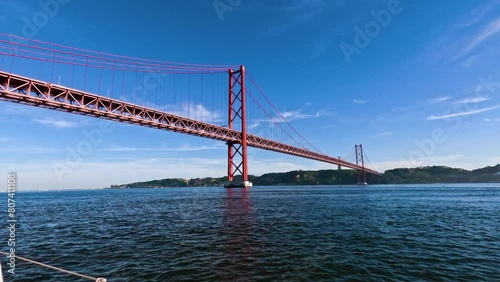 Sailing by Ponte 25 de Abril bridge in Lisbon Portugal photo