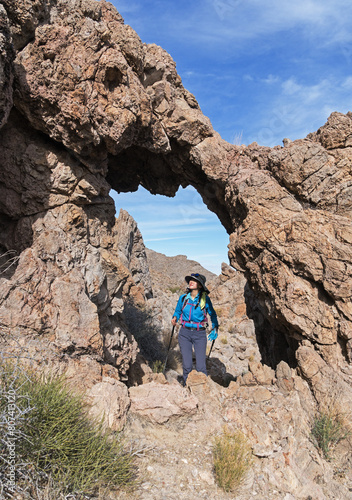 Woman Looks Up At Limestone Arch photo