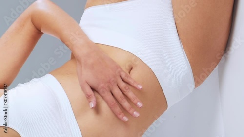 Wallpaper Mural Young, fit and beautiful woman in white swimsuit posing over grey background. Vertical video. Healthcare, diet, sport and fitness. Torontodigital.ca