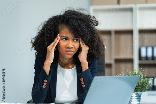 Obraz na plátně A young African American woman with Afro brown hair in a modern office experiencing panic, business-related stress, frustration, and anxiety