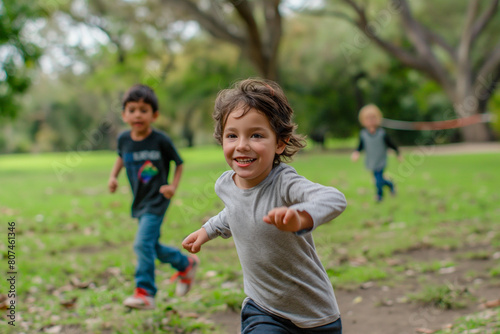 A young boy is running in a park with two other children (ID: 807461346)