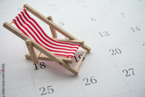 Red beach chair on white blank calendar background copy space. Annual leave travel period for relaxation concept. Period of paid time off (PTO) granted to employees by their employer.