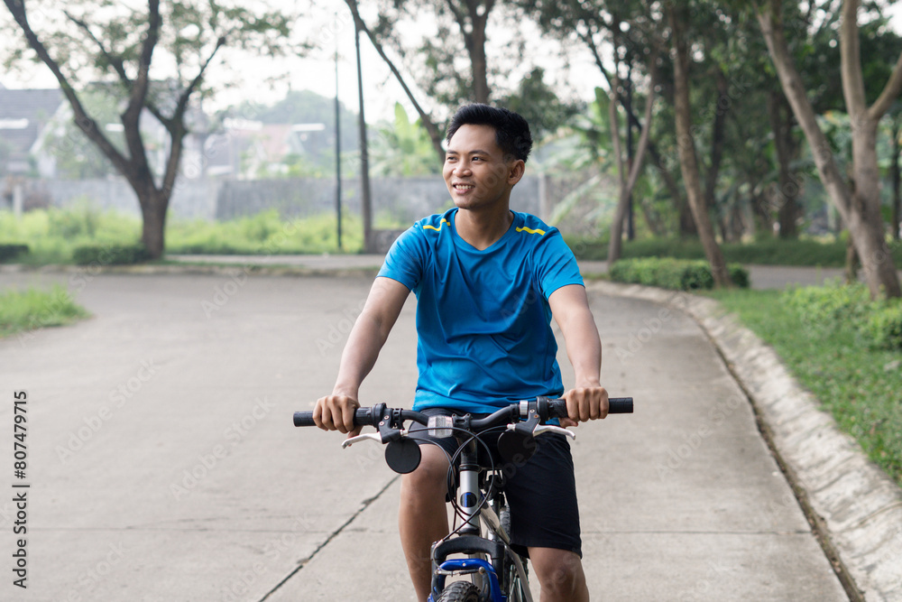 Obraz premium Asian Man Cycling in Blue Sports Shirt for Health and sport Ad.
