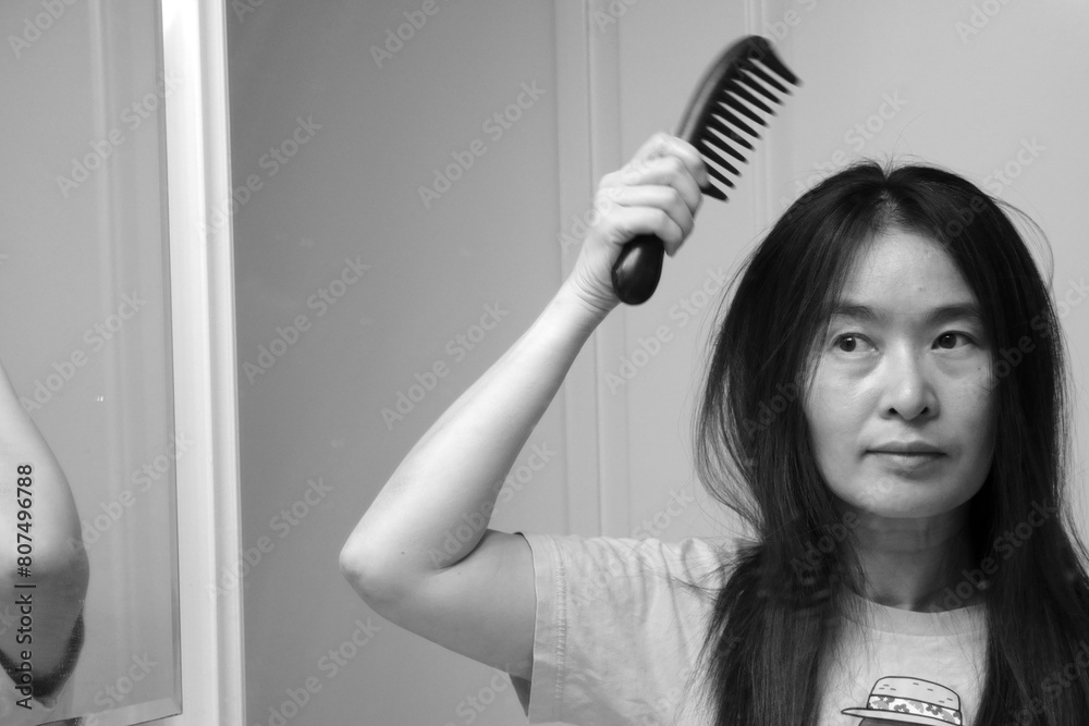 A woman is combing her hair. A woman is combing her hair.
