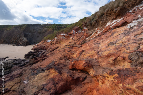 Coastal scenery rugged cliff at Forrest Caves Beach at Bass Strait  formed by rock erosion of cliffs. The eroding  red  basalt bluffs. Phillip Island  VIC Australia. 