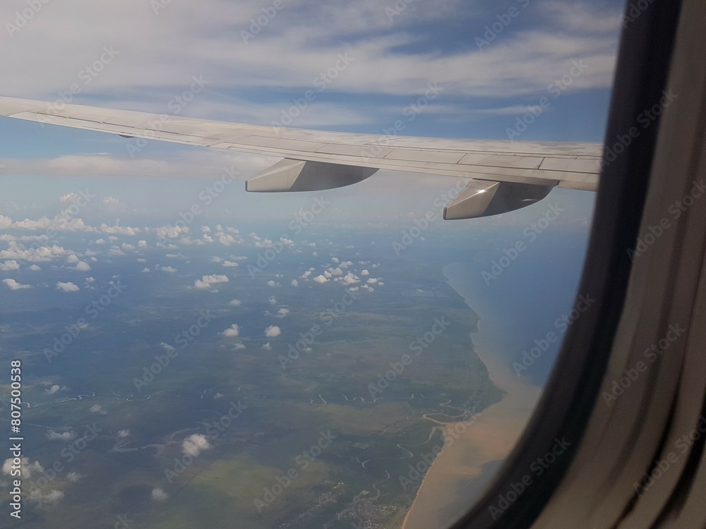 Looking through window aircraft during flight in wing with a nice blue clear sky and beautiful clouds. flying and traveling, view from airplane that can see outside. Looking through window aircraft during flight in wing with a nice blue clear sky and beautiful clouds. flying and traveling, view from airplane that can see outside.