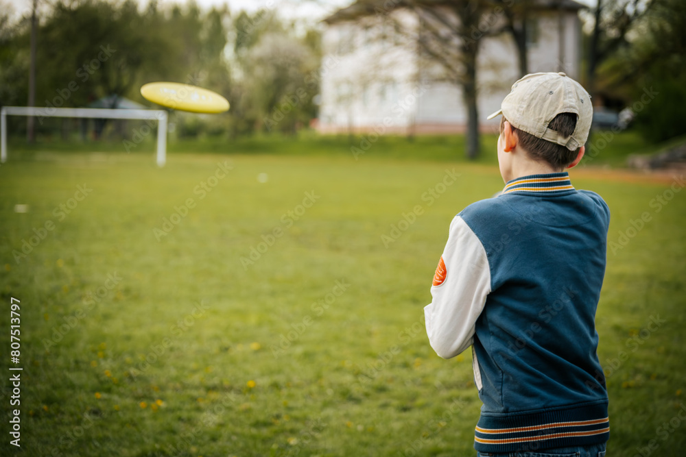 A boy throws disc golf. A young boy learns to throw a discus A boy throws disc golf. A young boy learns to throw a discus