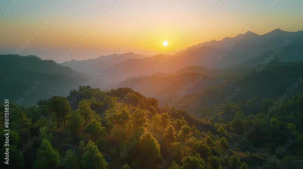 mountain majesty at dawn with a stunning orange and yellow sun setting against a blue sky, framed by a lush green tree mountain majesty at dawn with a stunning orange and yellow sun setting against a blue sky, framed by a lush green tree