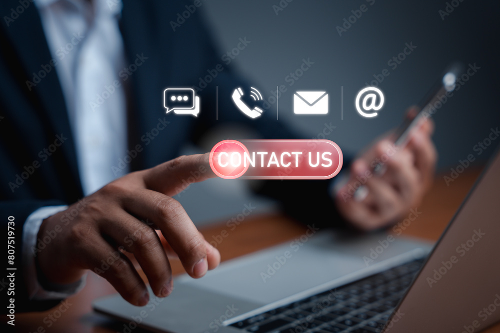 Businessman using a laptop and touch on virtual screen contact icons(live chat, phone, email, address). Contact us or the Customer support hotline people connect Businessman using a laptop and touch on virtual screen contact icons(live chat, phone, email, address). Contact us or the Customer support hotline people connect