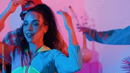 Close up of break dancer team dancing together at modern studio with pink led light. Multicultural people moving to hip hop music while wearing stylish fashion cloth. Crazy, funny mood. Regalement. photo